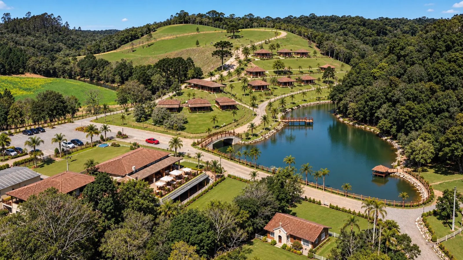 Vista do acesso principal, estacionamento junto ao lago e ruas ladeadas por palmeiras imperiais